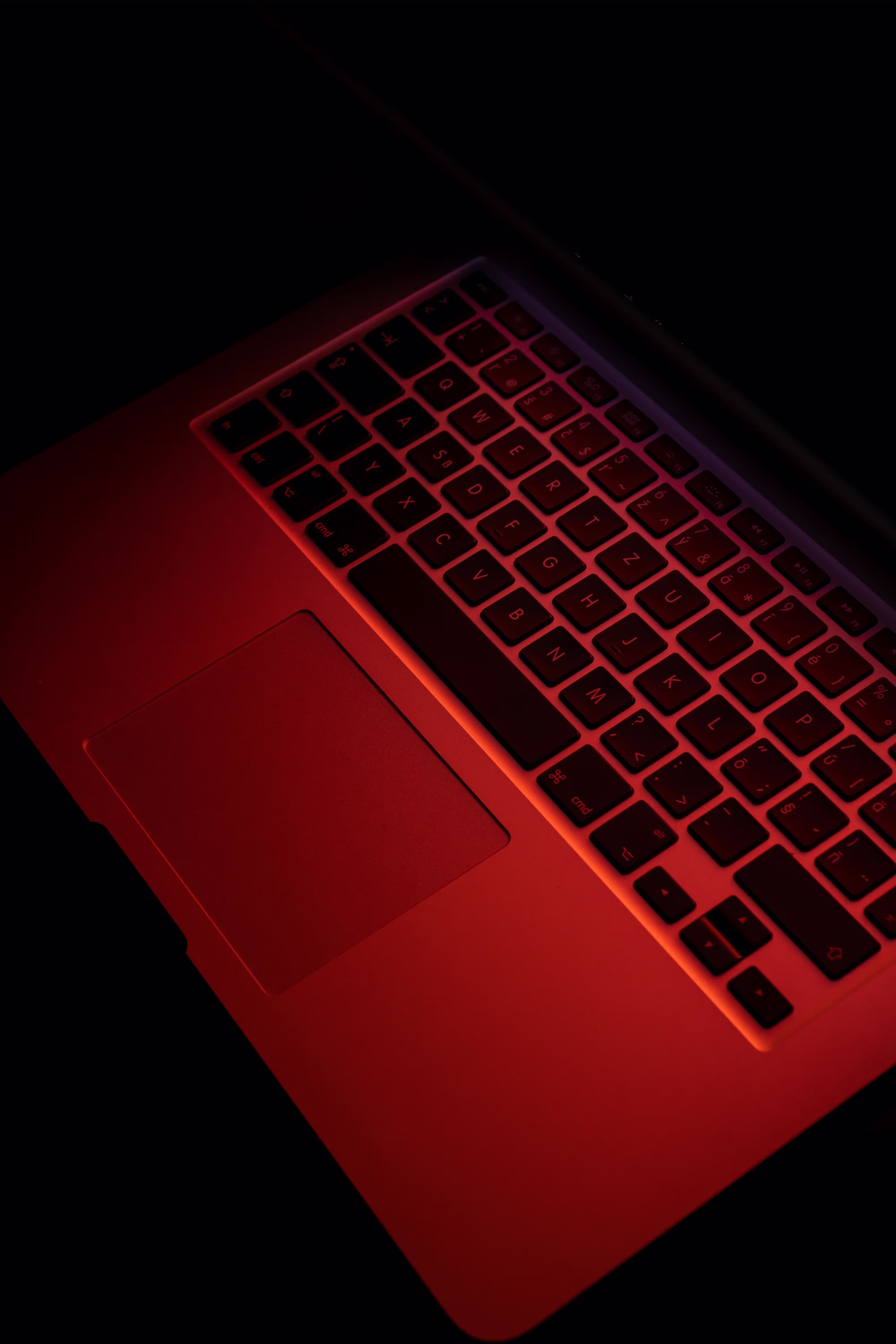 Ein Laptop, dessen Tastatur rot beleuchtet ist.